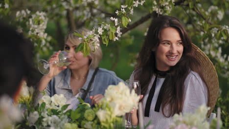 hen-party-in-blooming-garden-in-spring-weekend-joyful-ladies-are-drinking-wine-and-cocktails